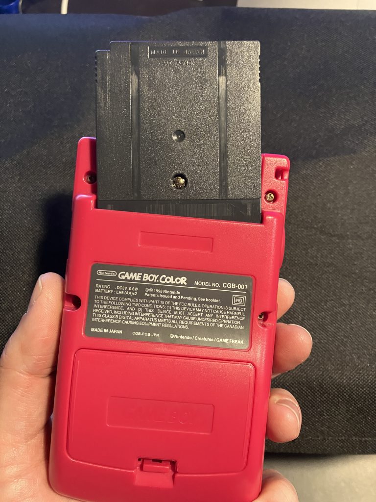 A Game Boy cart placed incorrectly into the Game Boy. The label is facing the wrong way and the cart is angled showing that it will not accept the cart in this orientation.