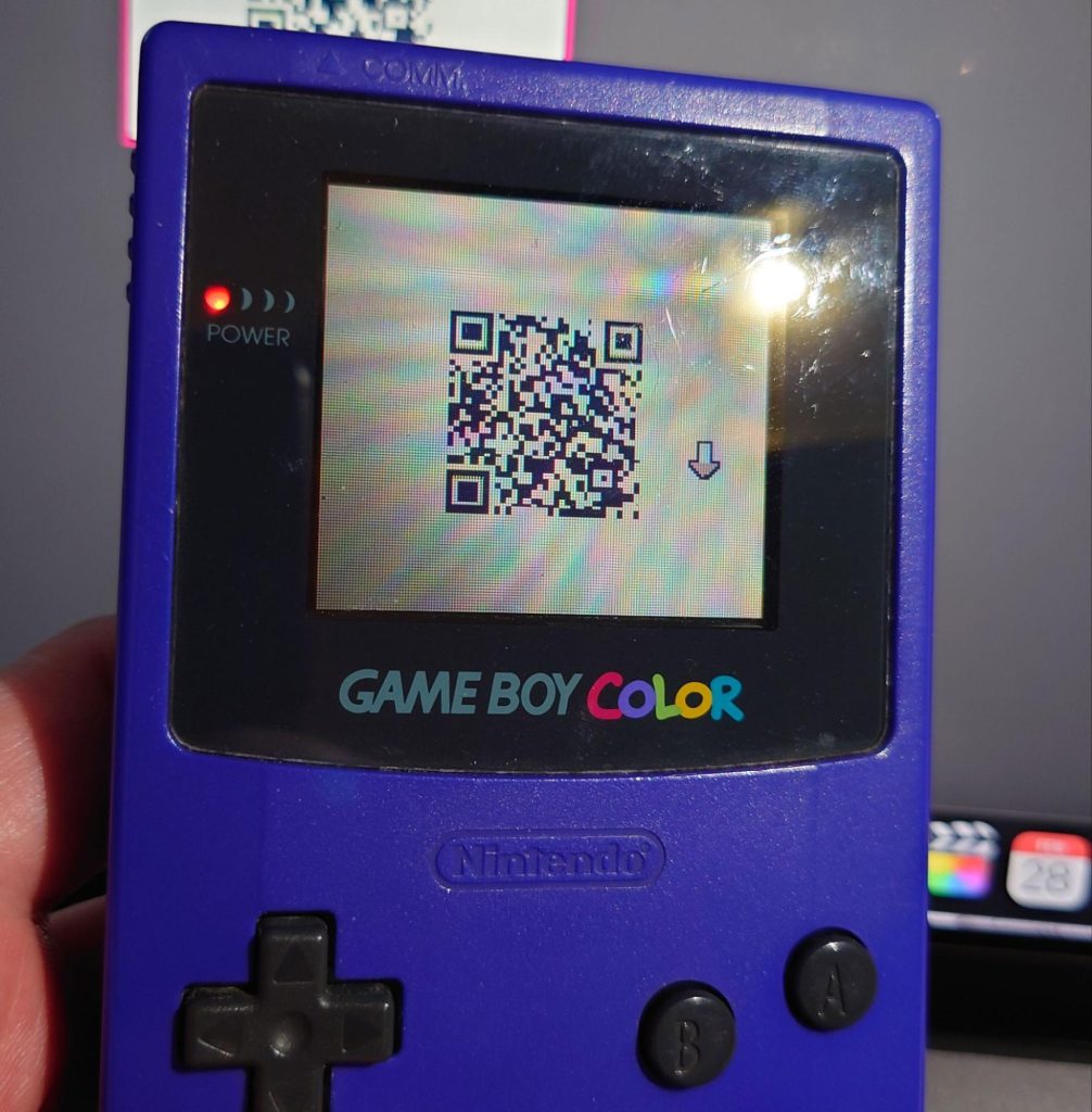 A photo of the smaller QR code being displayed on an actual game boy.